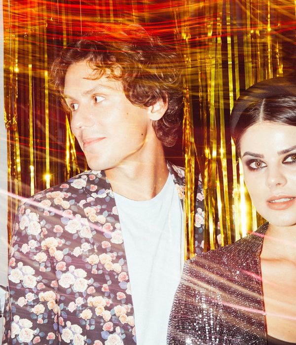 Person in a dynamic but controlled stretching pose in a spacious, light room.